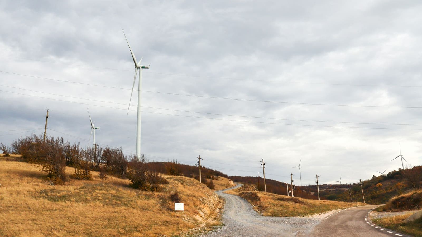 Drum de țară, cu o turbină eoliană în fundal